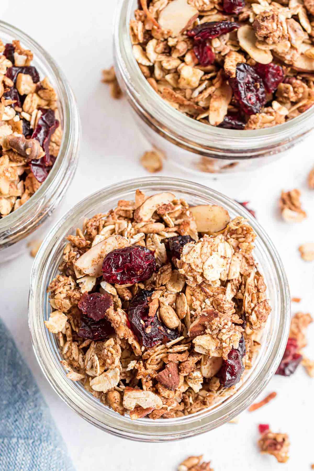 Vue aérienne de granola dans de petits bocaux en verre.