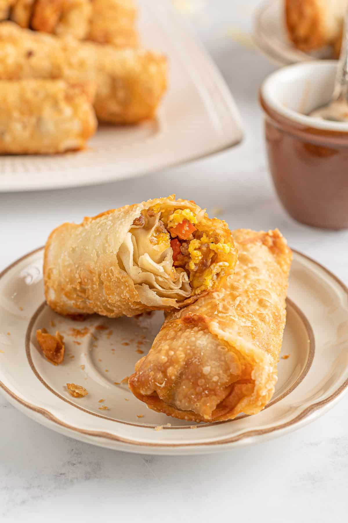 Deux rouleaux de printemps au petit-déjeuner, l'un coupé pour montrer la texture.