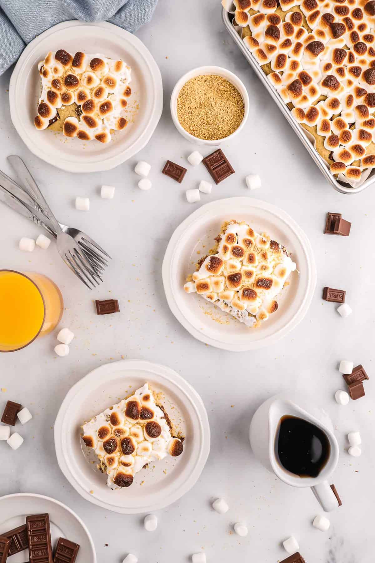Vue plongeante de trois assiettes de pancakes s'mores avec une plaque de plus également visible.