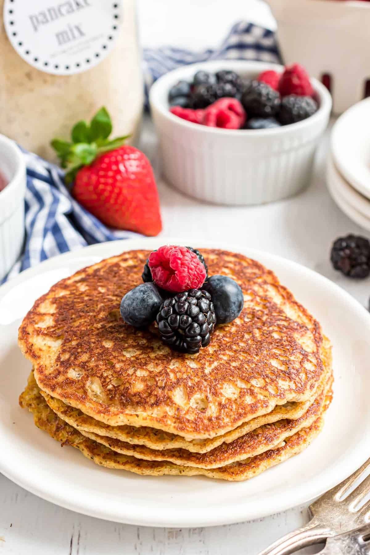 Pancakes keto avec un pot de mélange à pancakes en arrière-plan.