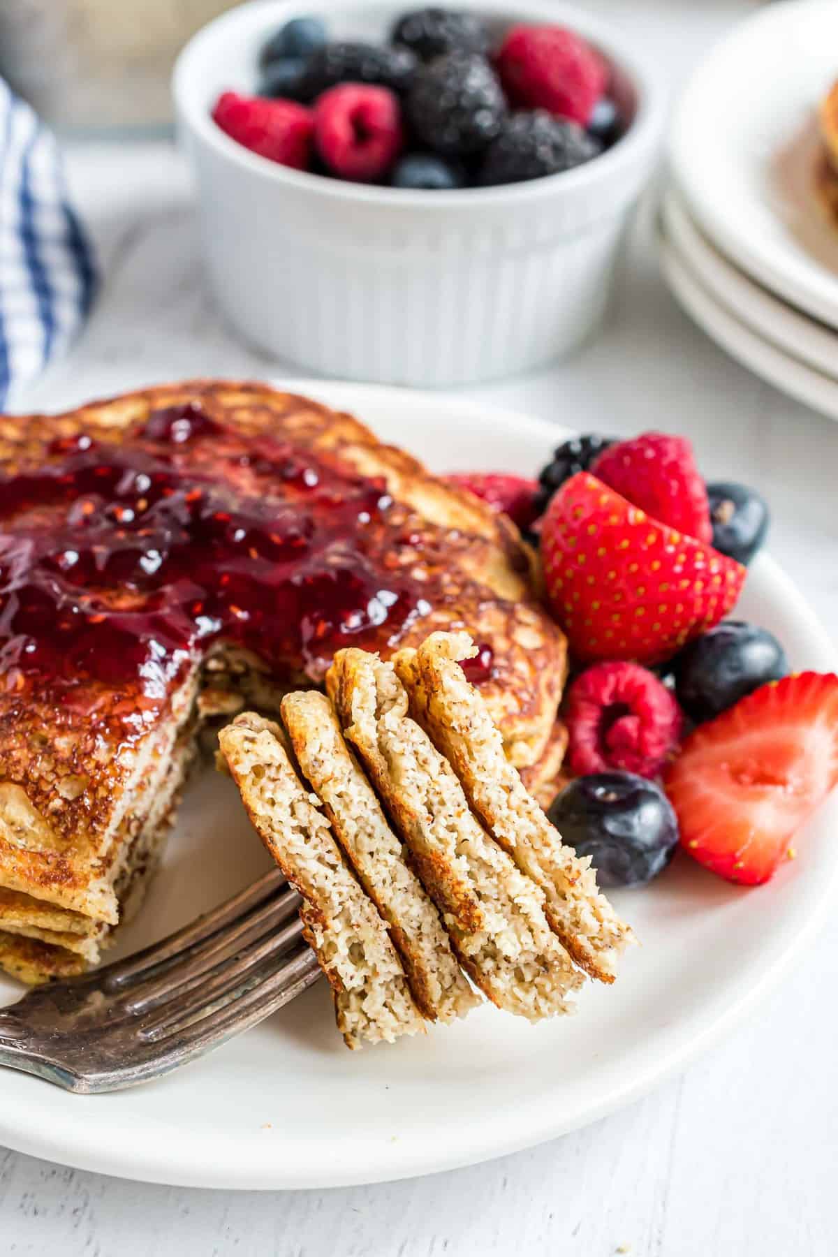 Pancakes sur une fourchette avec une pile en arrière-plan.