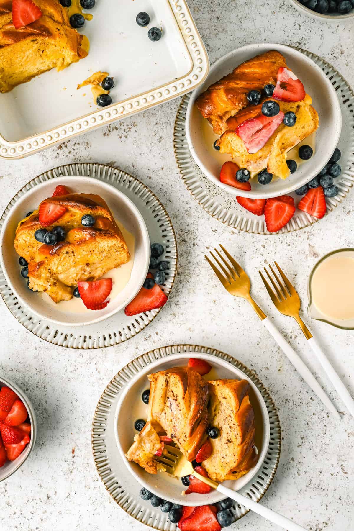 Trois assiettes de casserole de pain perdu avec des fruits.
