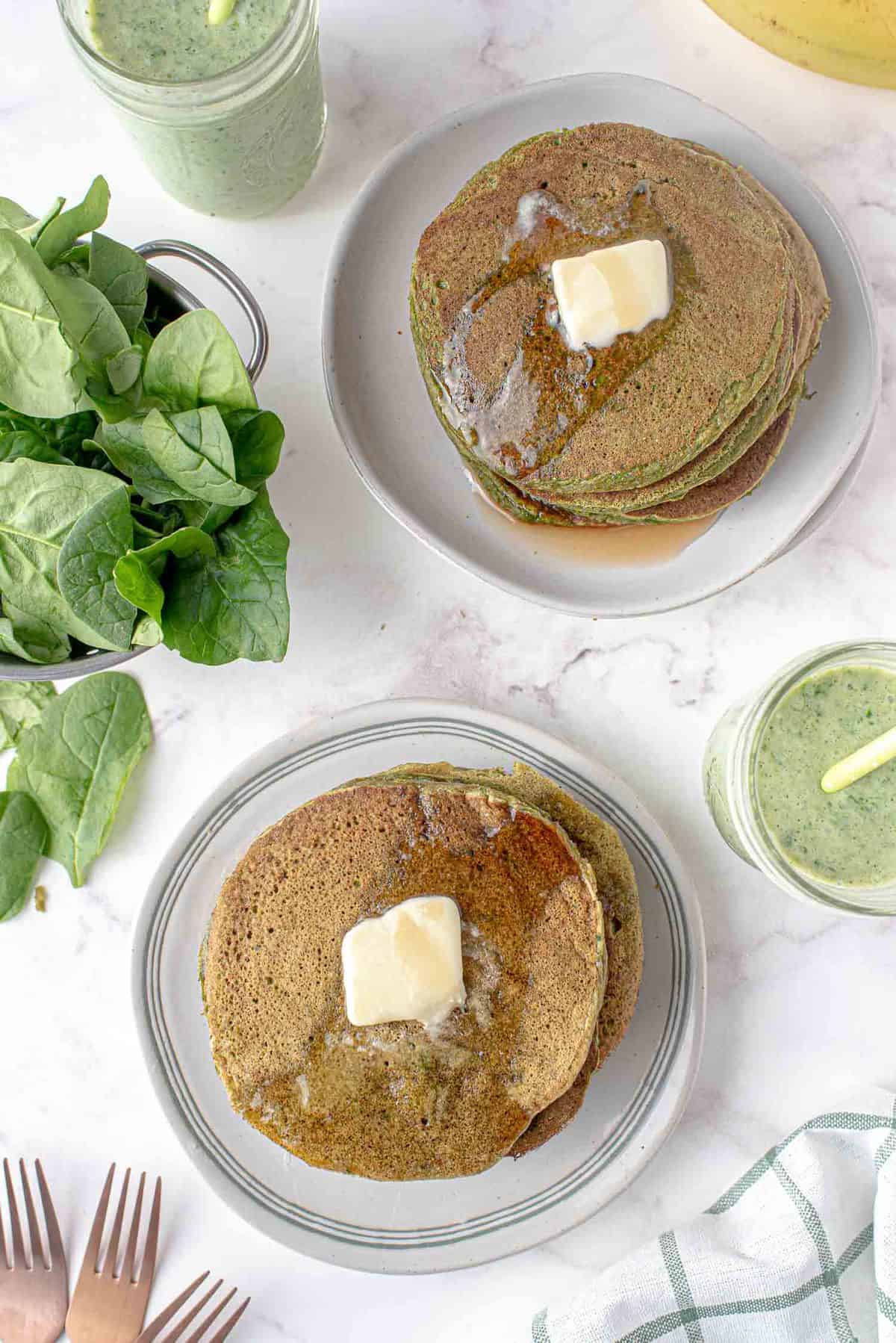 Vue aérienne de deux piles de pancakes garnies de beurre.