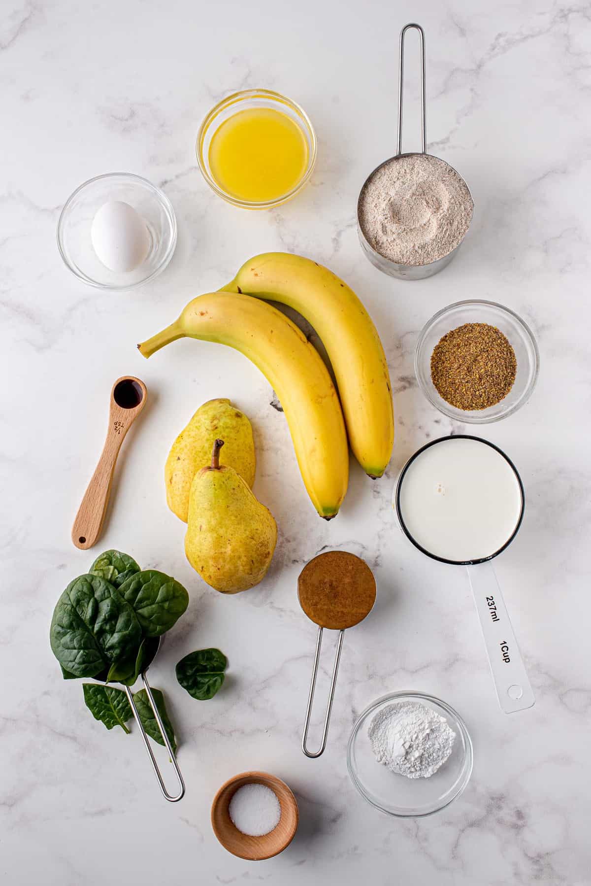 Vue aérienne des ingrédients nécessaires pour la recette incluant des épinards et des bananes.