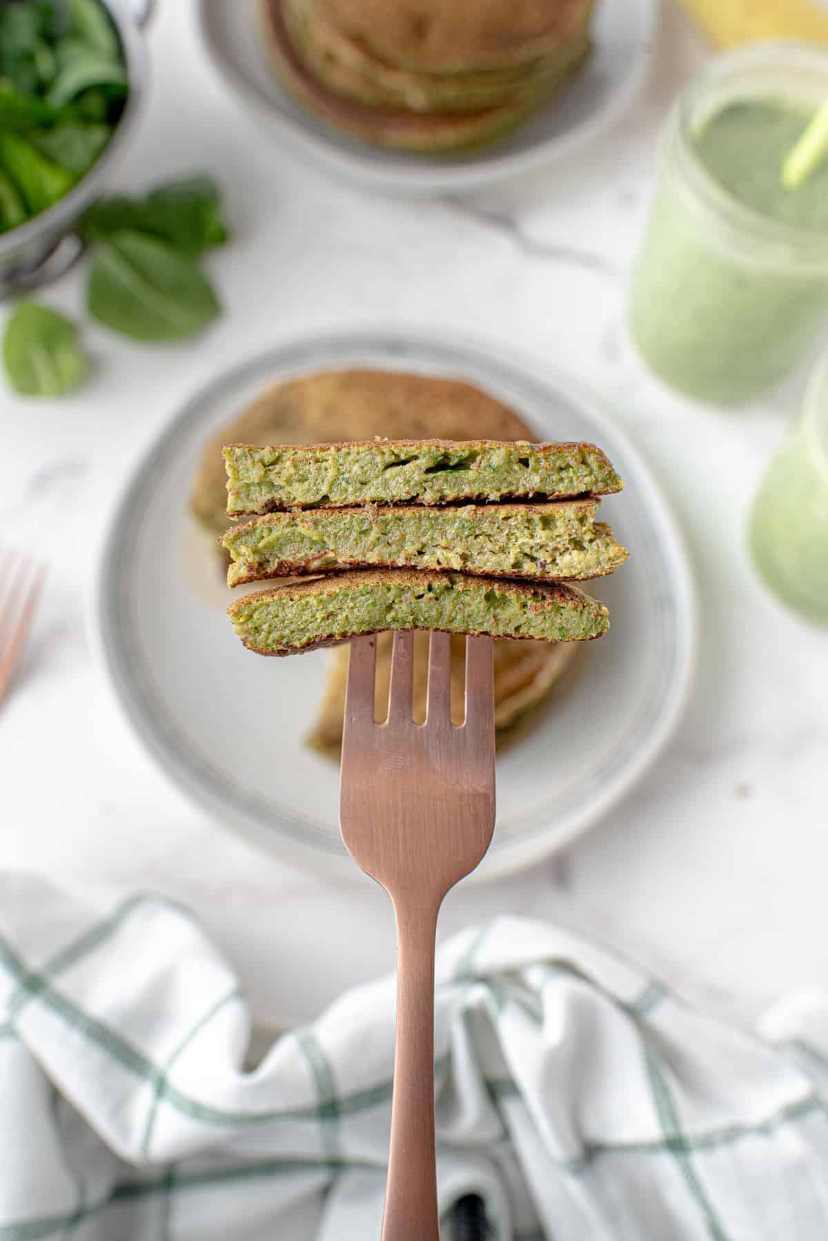 Pancakes de smoothie vert coupés sur une fourchette.