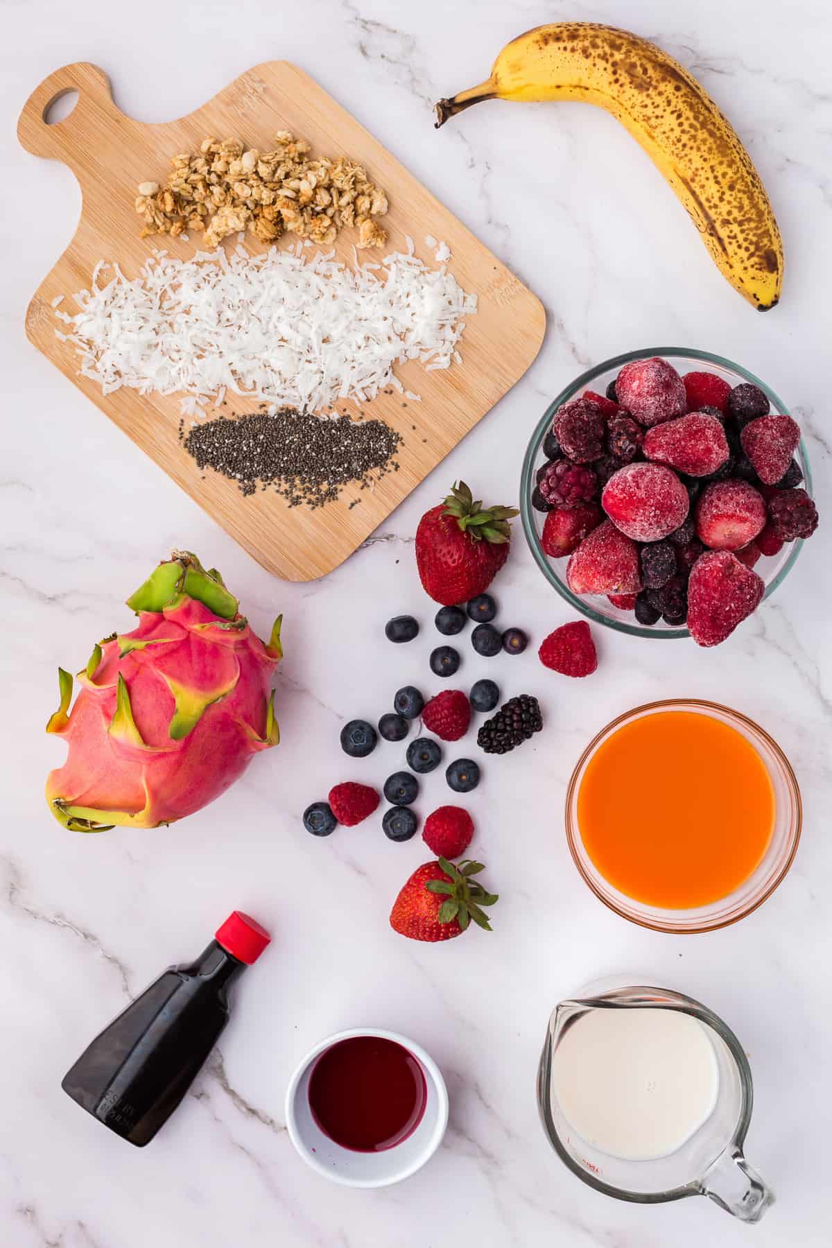 Ingrédients nécessaires à la recette, y compris des baies mélangées surgelées et une banane.