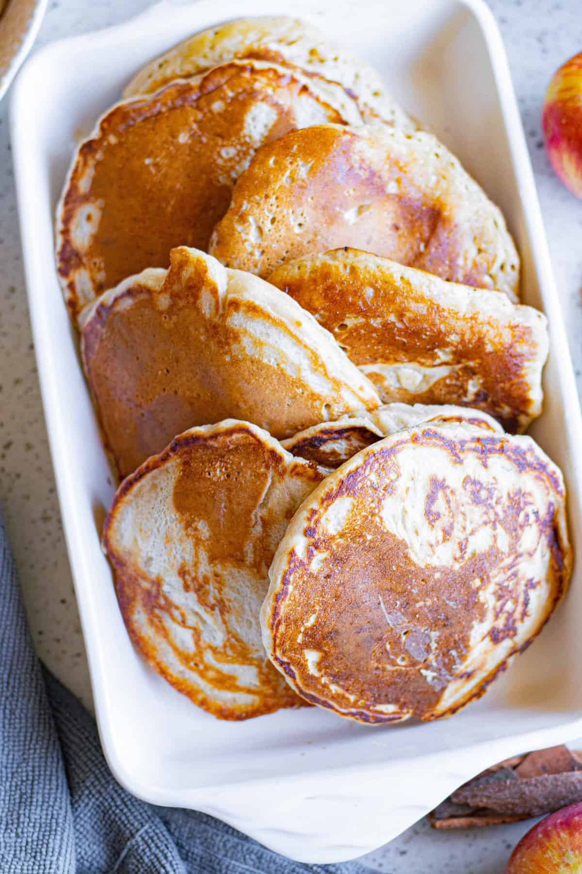 Pancakes aux pommes sans garniture sur un plat blanc.