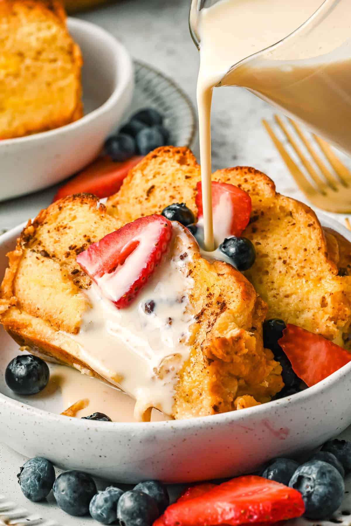 Casserole de pain perdu tres leches garnie de fruits rouges.