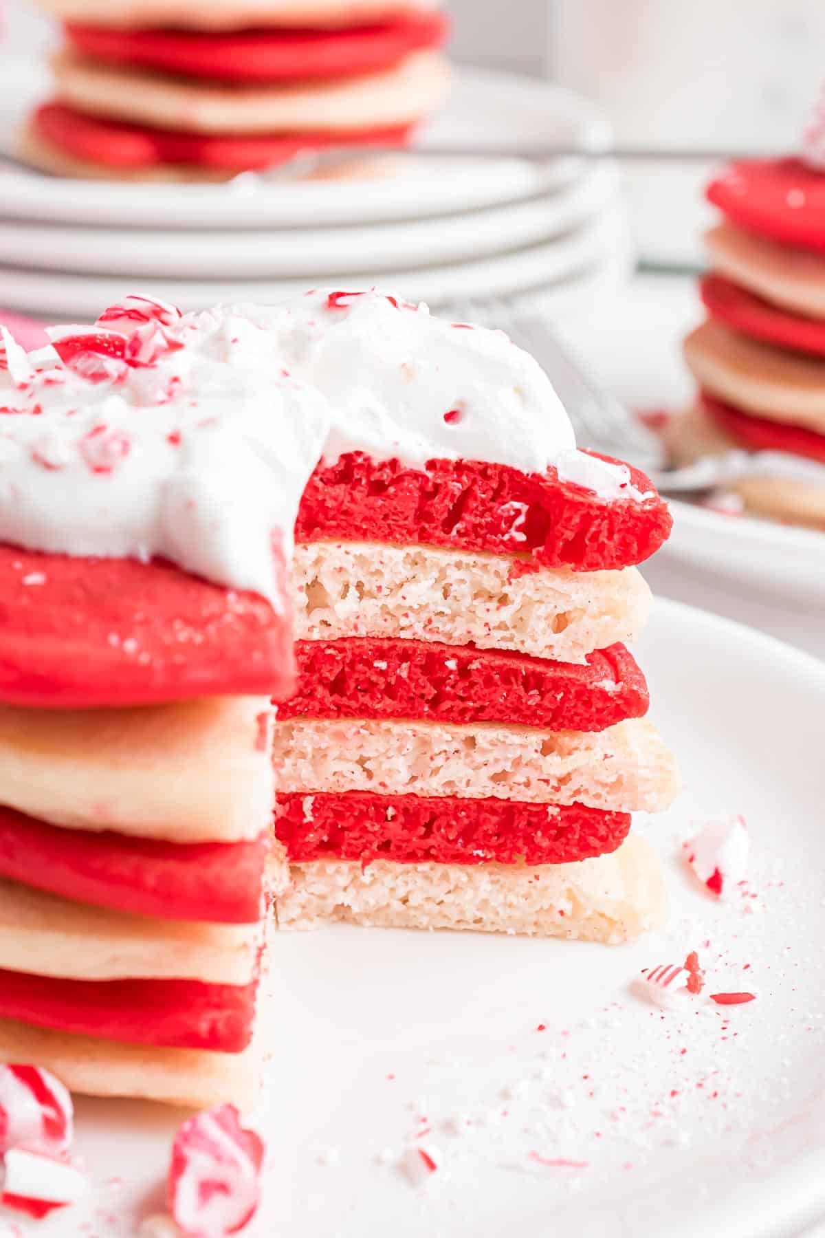 Pancakes empilés rouges et blancs avec de la crème fouettée.