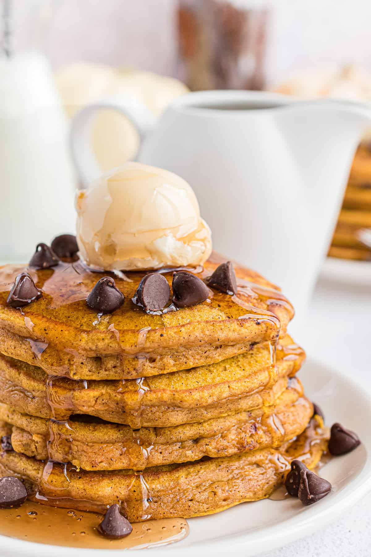 Empilement de pancakes à la citrouille avec pépites de chocolat, beurre et sirop.