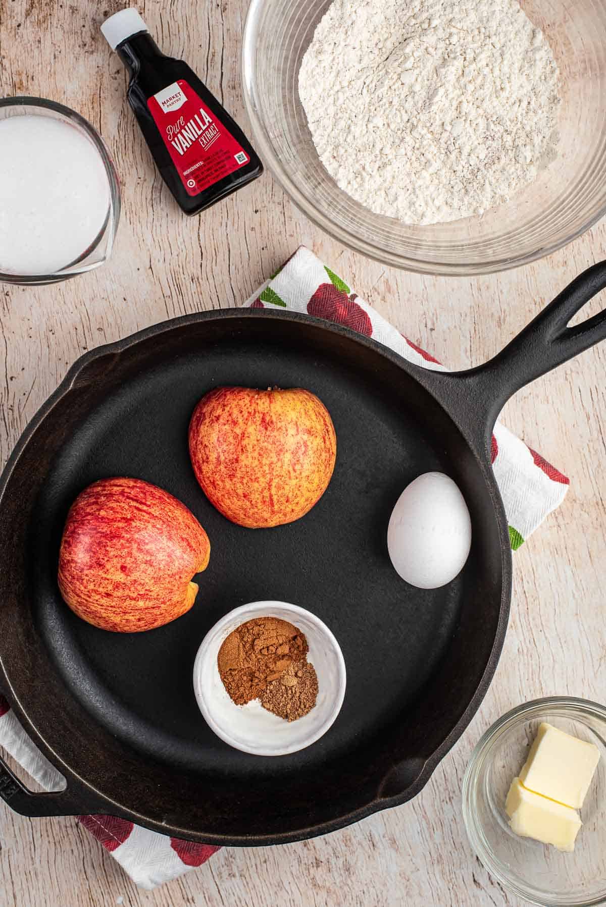 Ingrédients pour le pancake aux pommes et une poêle noire.