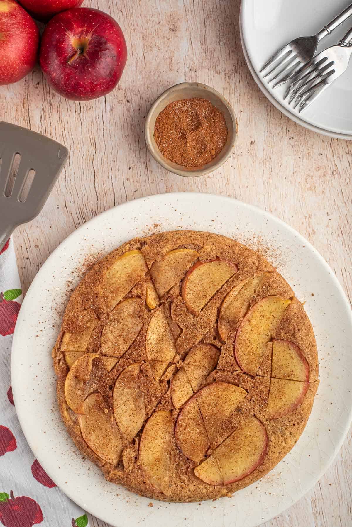 Vue de haut d'un grand pancake aux pommes, coupé en quartiers.