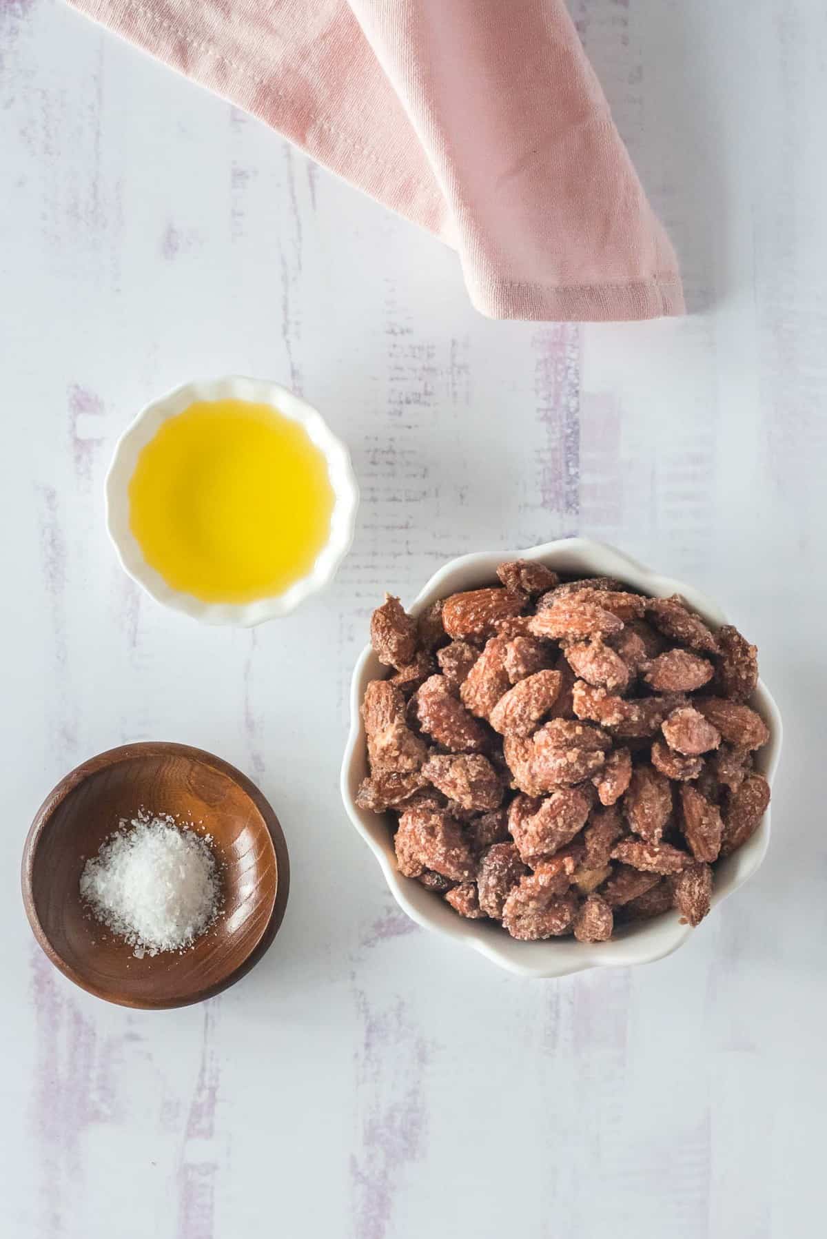 Vue d'ensemble des ingrédients dans des bols : amandes, sel et huile.