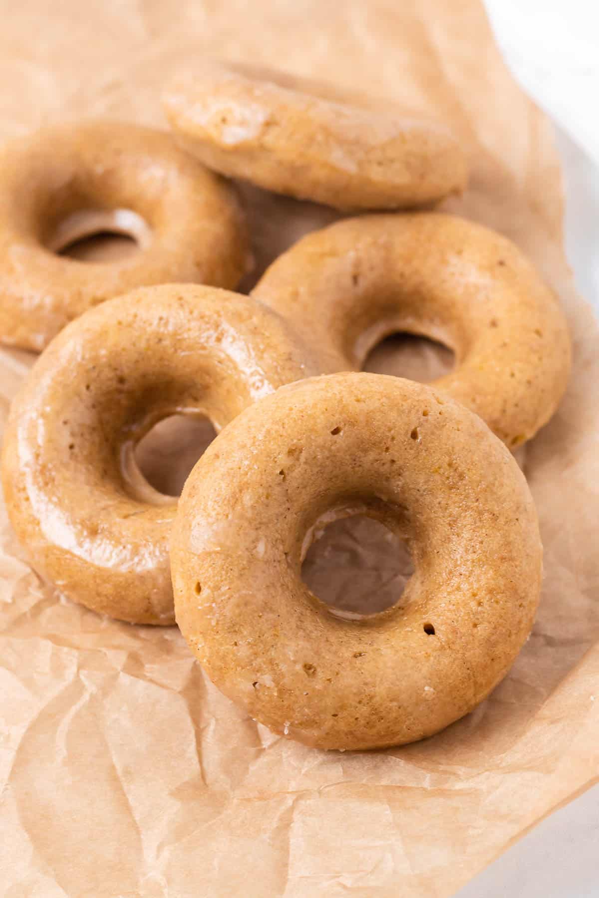 Pile de donuts brun clair sur un papier brun.