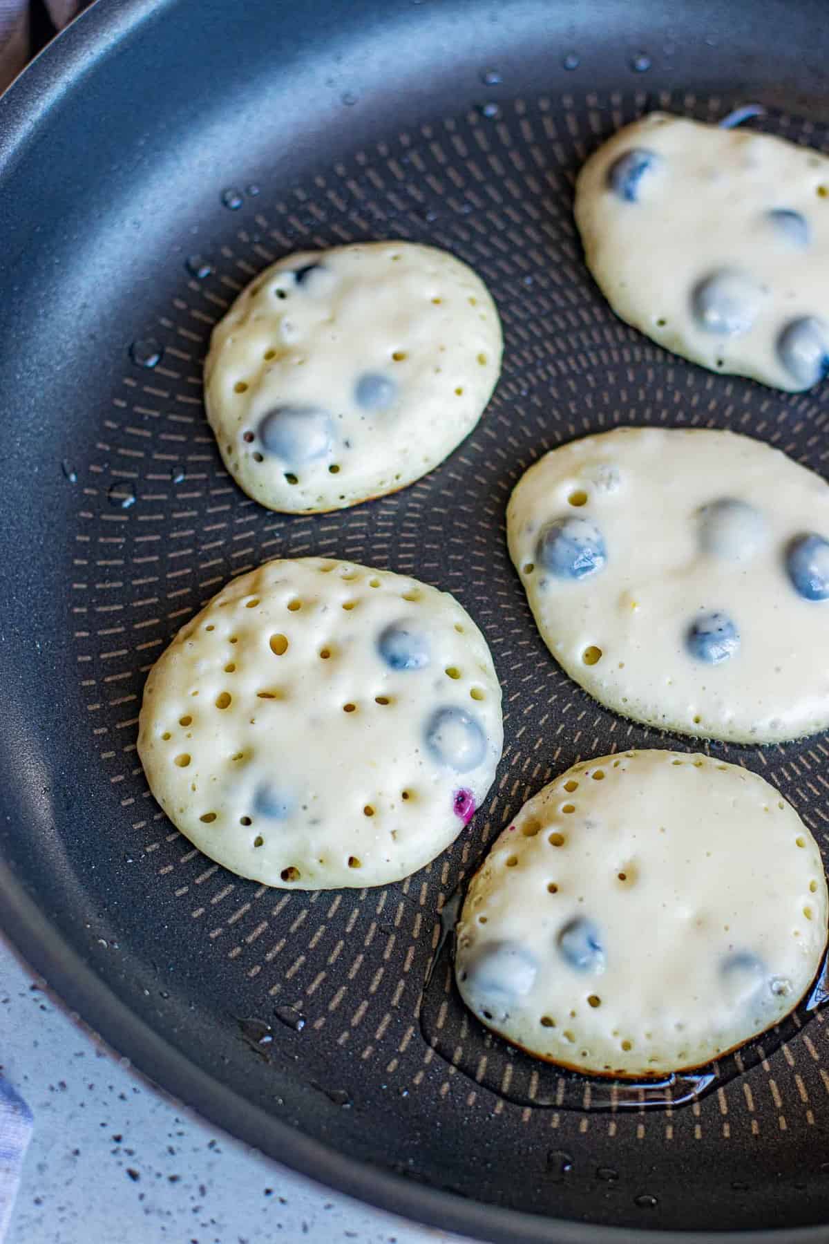 Pancakes cuisant dans une poêle.