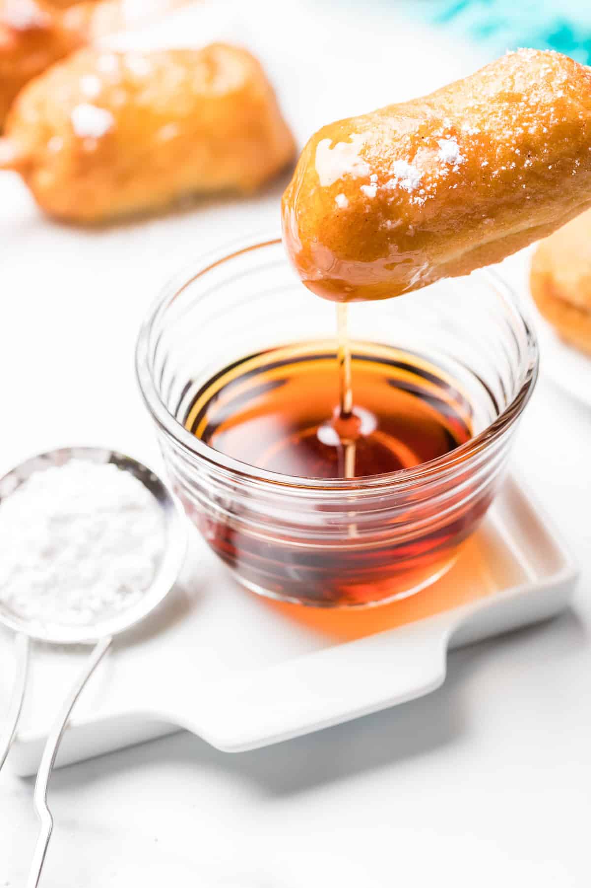Beignets sur un plateau avec du sucre glace et du sirop d'érable.