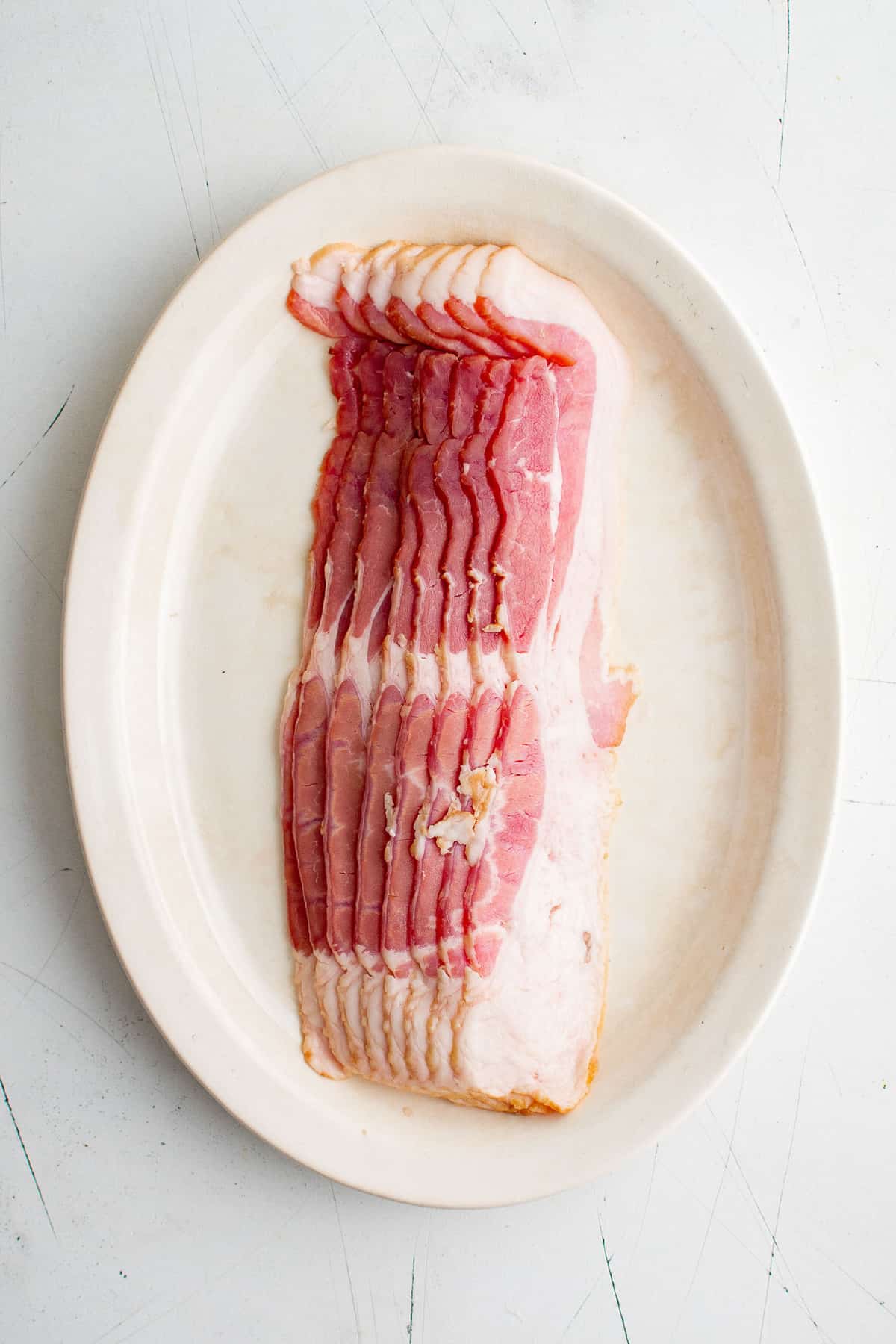 Bacon cru sur une assiette.