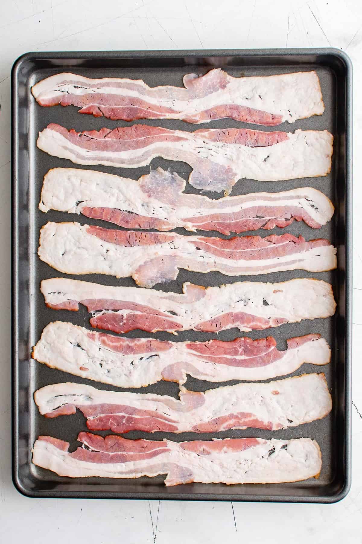 Bacon sur une plaque de cuisson, cru.