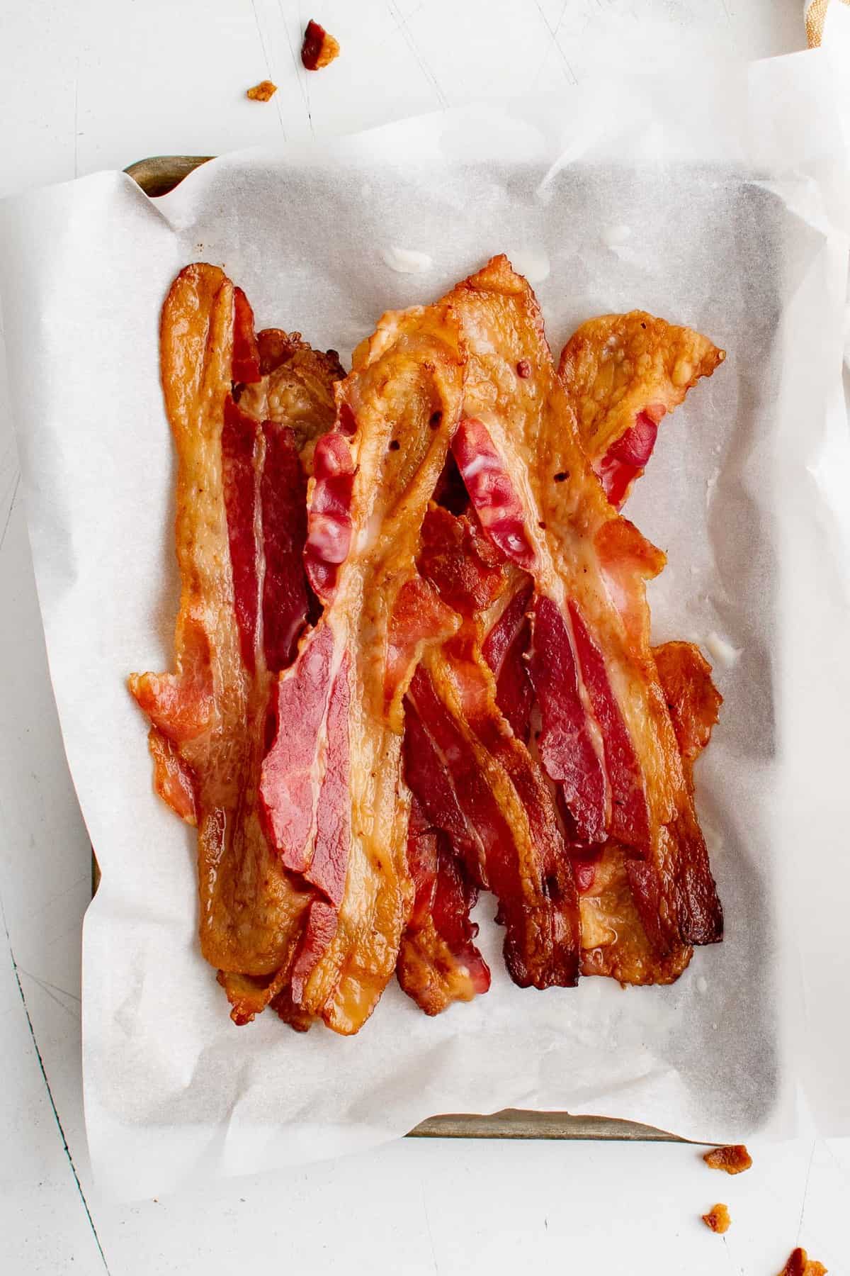 Bacon sur une assiette tapissée de serviettes en papier.