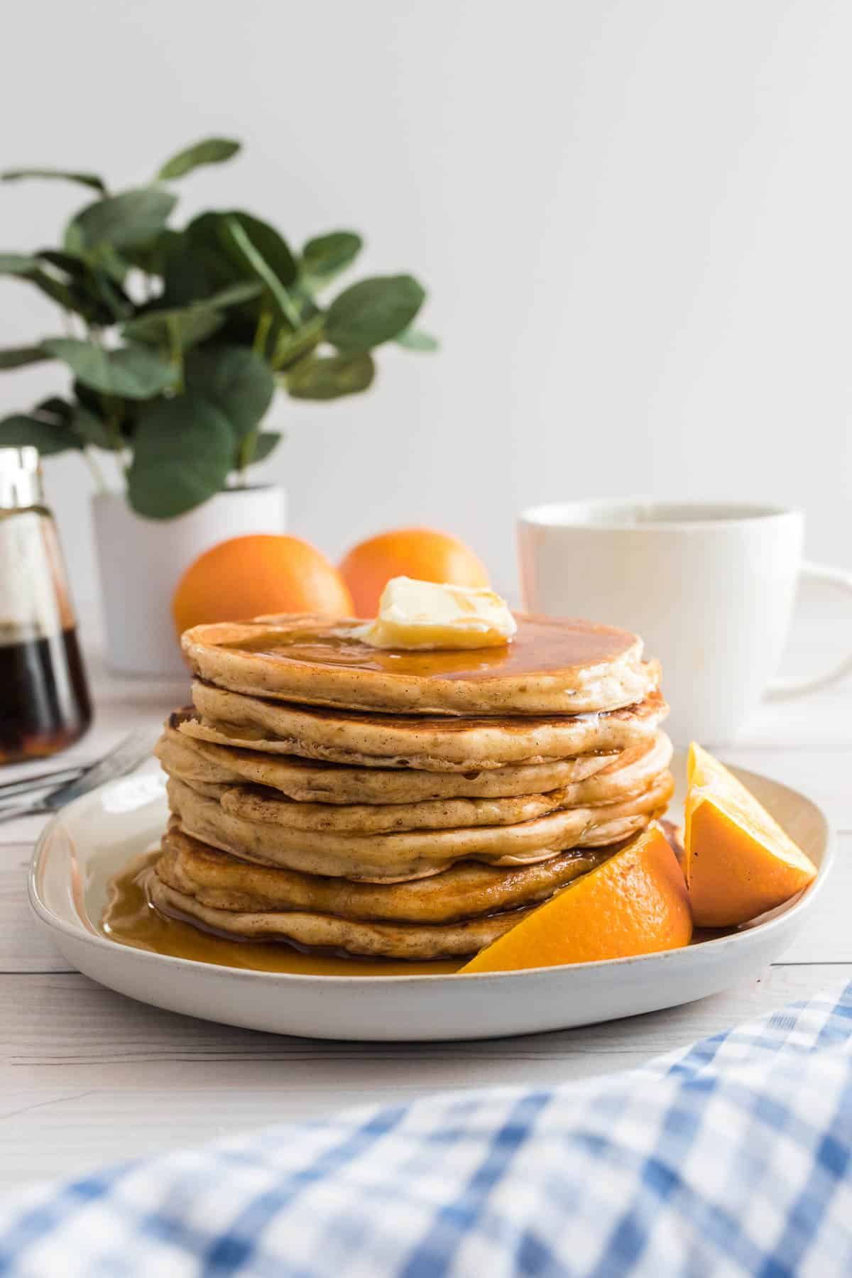 Tas de pancakes à l'orange sur une assiette blanche.