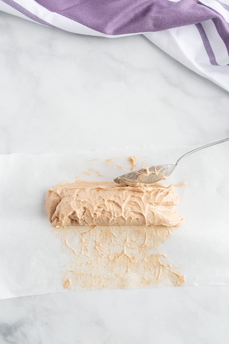 Beurre à la vanille et à la cannelle à l'érable formé en bûche sur du papier sulfurisé.