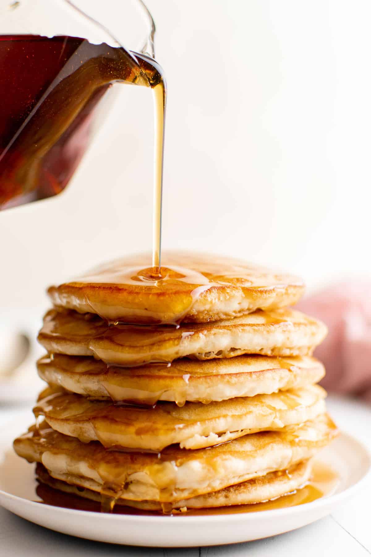 Sirop versé sur une pile de pancakes.