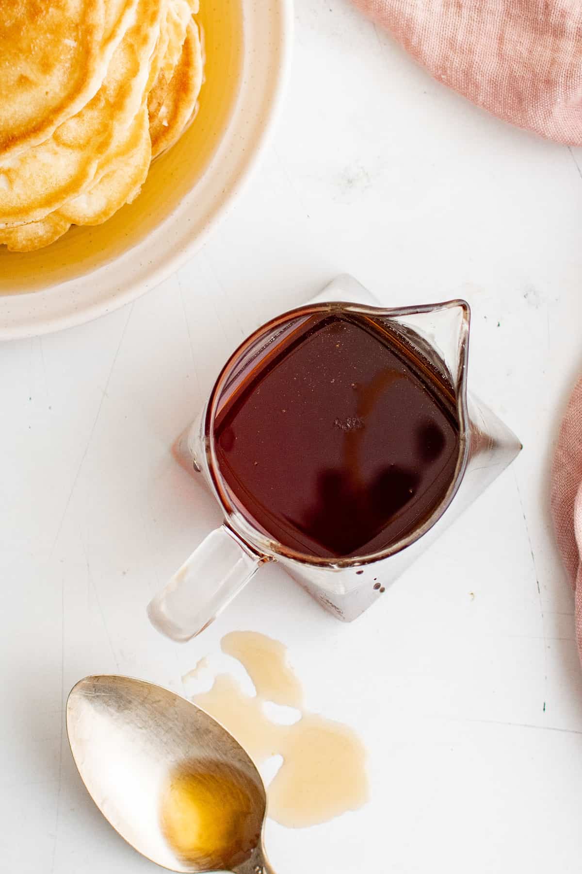 Vue aérienne du sirop pour pancakes dans un petit bocal en verre transparent.