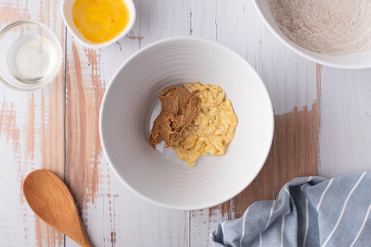 Banane écrasée et beurre de cacahuète dans un bol de mélange.