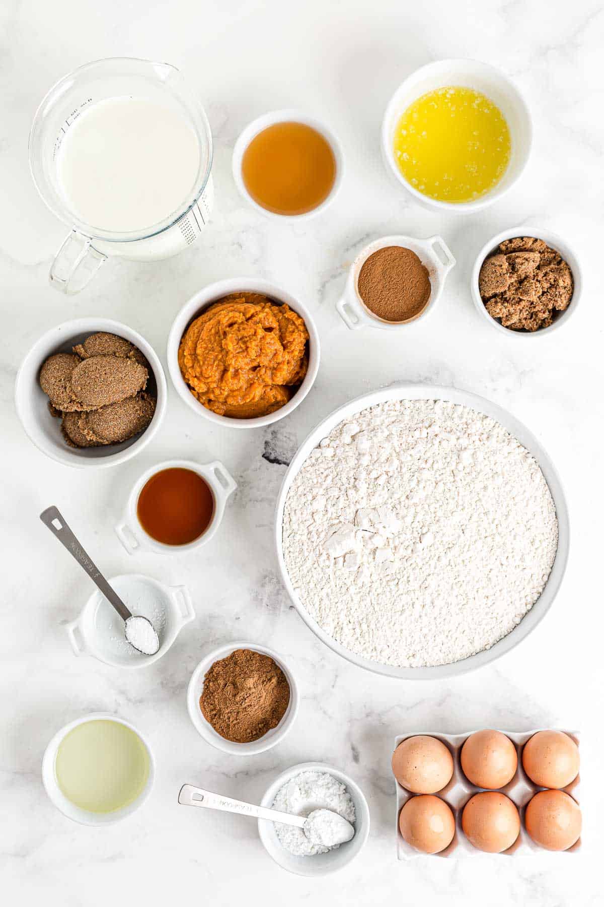 Ingrédients pour les pancakes à la courge sur un fond blanc.