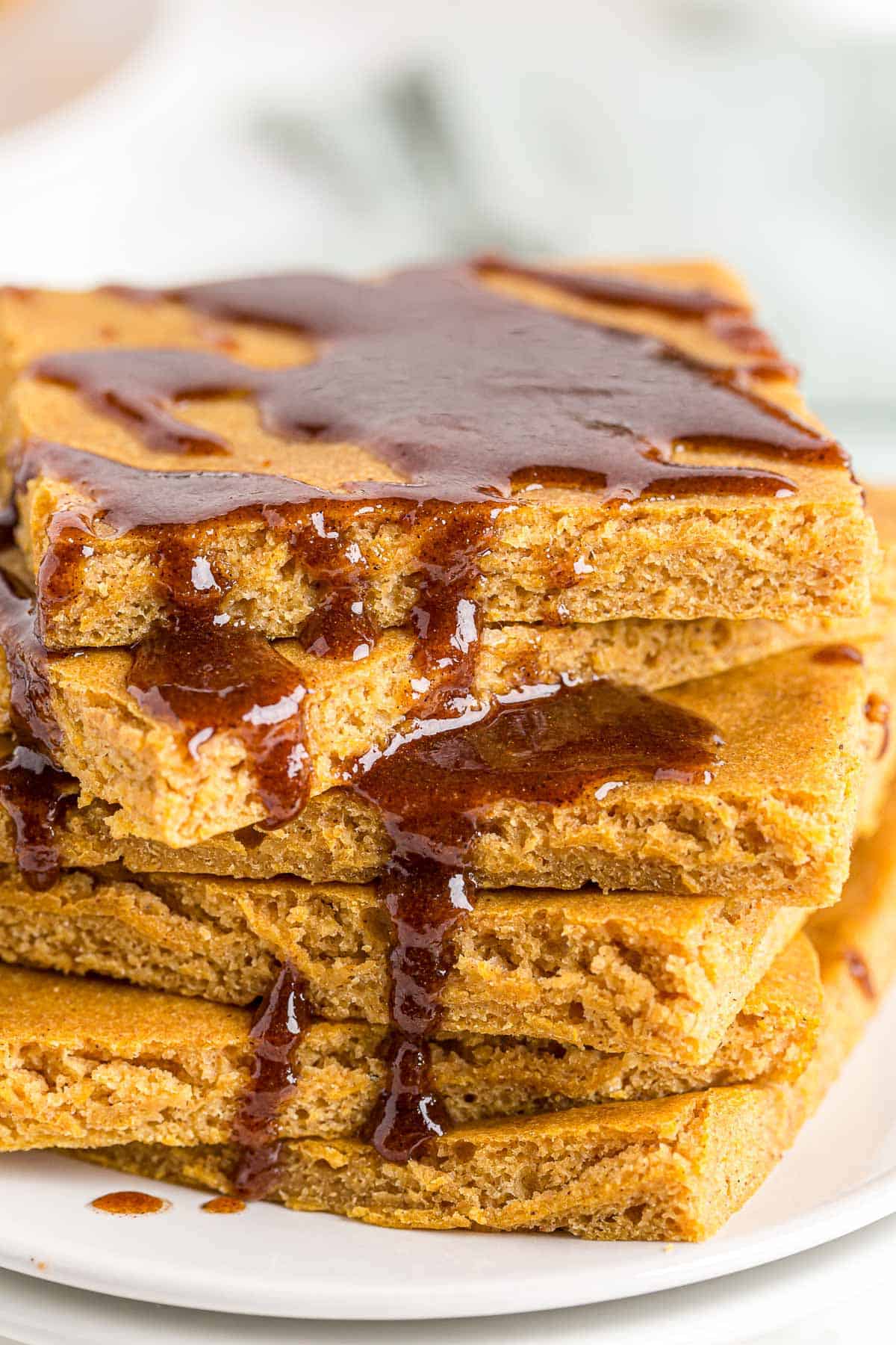 Coulis de beurre à la cannelle dégoulinant d'une pile de pancakes.
