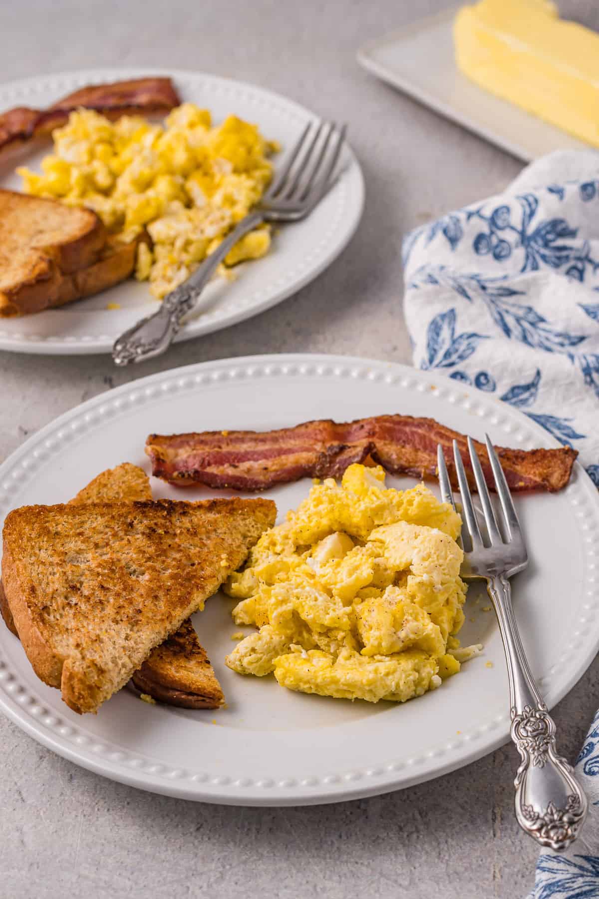 Des œufs brouillés sur un plateau avec du bacon et du pain grillé.