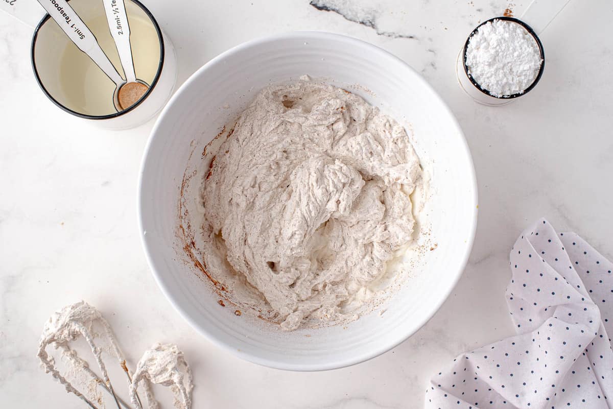 Crème fouettée à la cannelle dans un bol blanc.