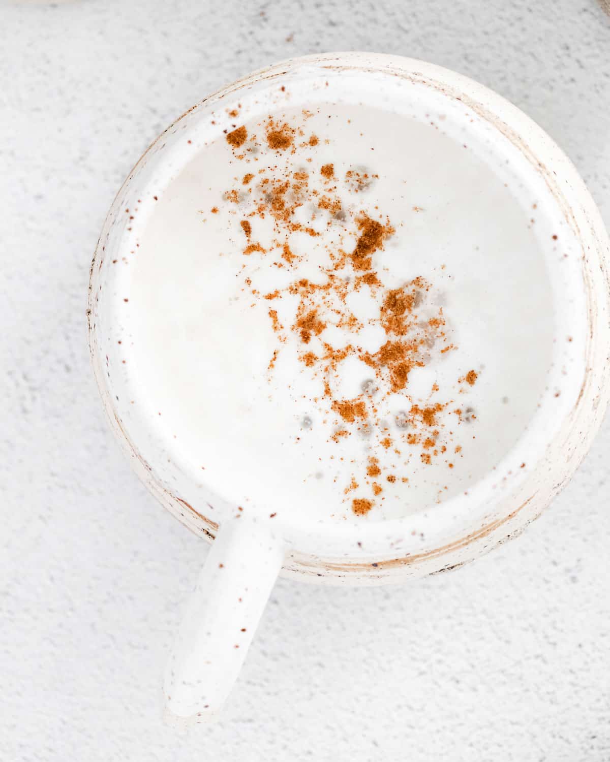Vue aérienne d'un latte à la citrouille épicée dans une tasse blanche.