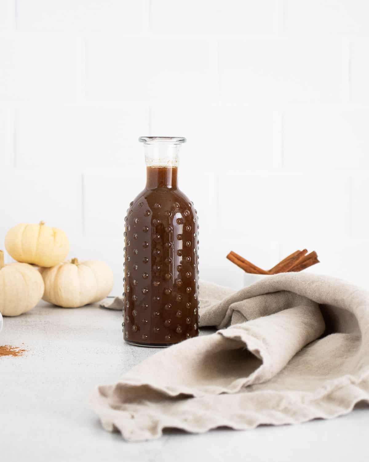 Sirop à la citrouille et au sucre brun dans une bouteille en verre.