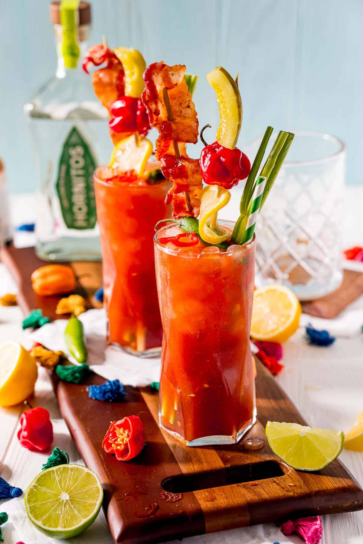 Cocktails à base de jus de tomate sur un plateau en bois.