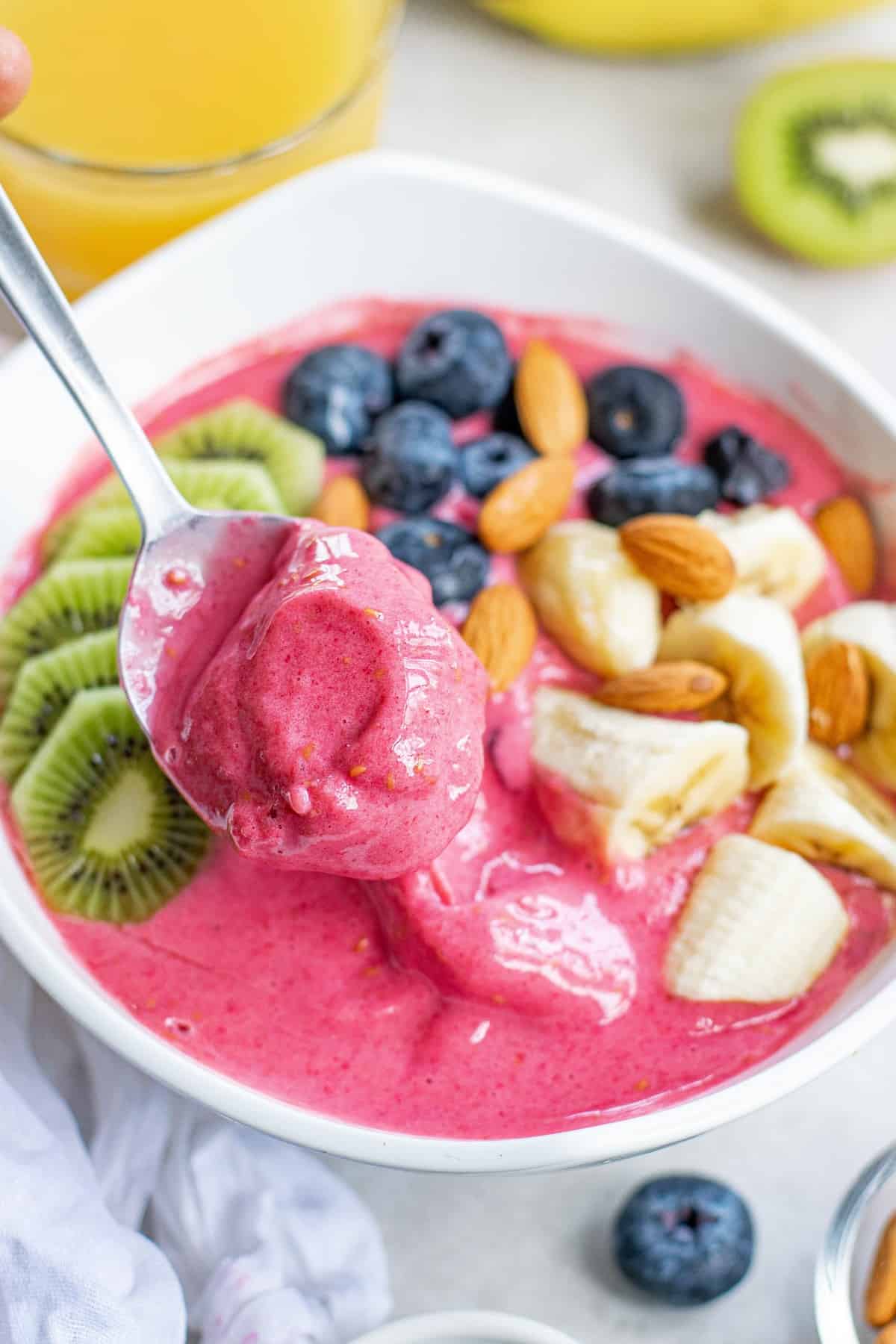 CuillĂšre plongeant dans le bol de smoothie.