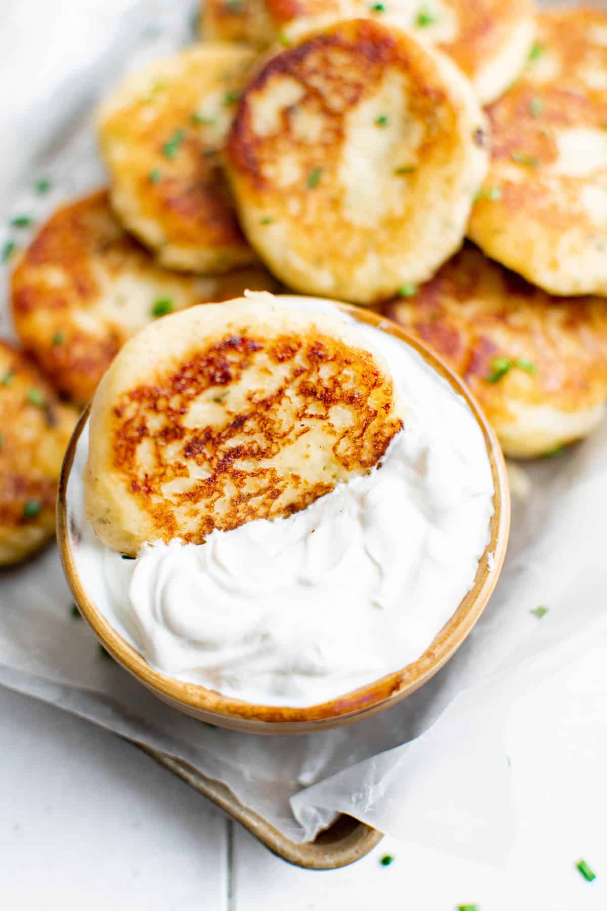Pancake de pomme de terre trempé dans un bol de crème aigre.