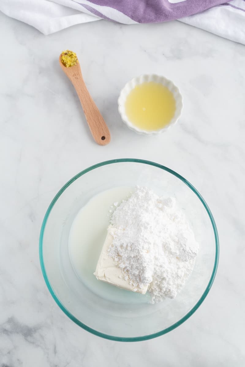 Sucre glace, fromage frais et lait dans un petit bol de mélange.