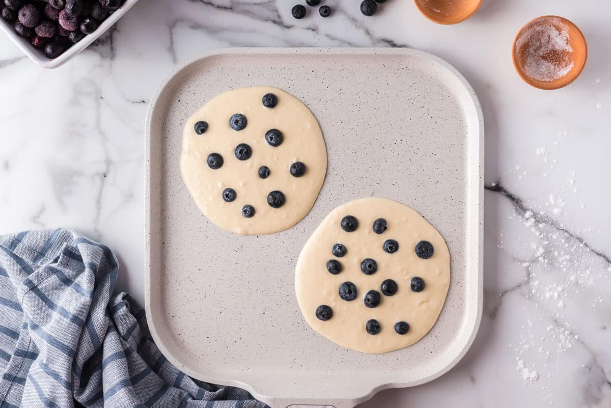 Pancakes aux myrtilles non cuits sur une poêle.
