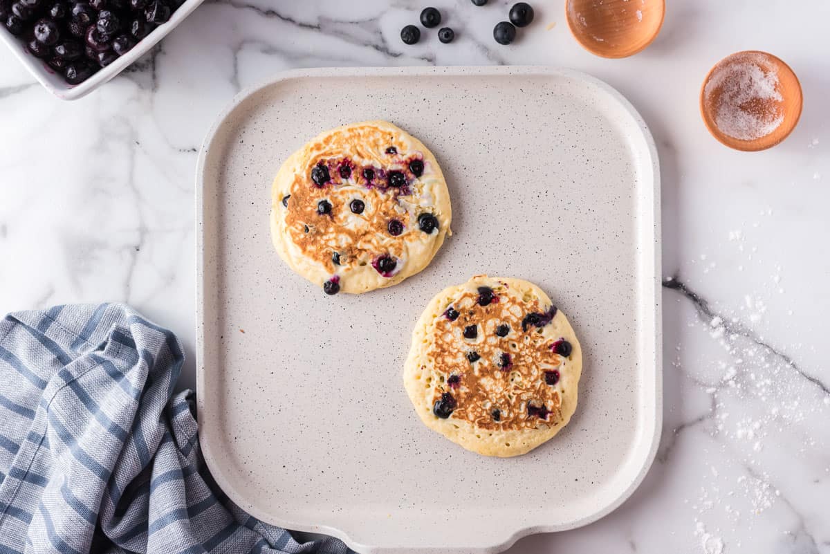 Pancakes aux myrtilles sur une poêle.