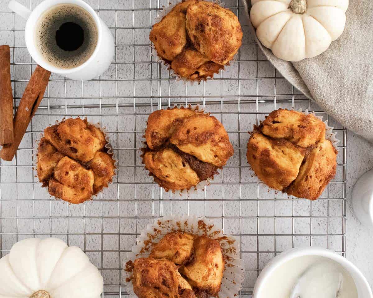 Vue aérienne de muffins de pain de singe, citrouilles blanches et café dans des tasses blanches.