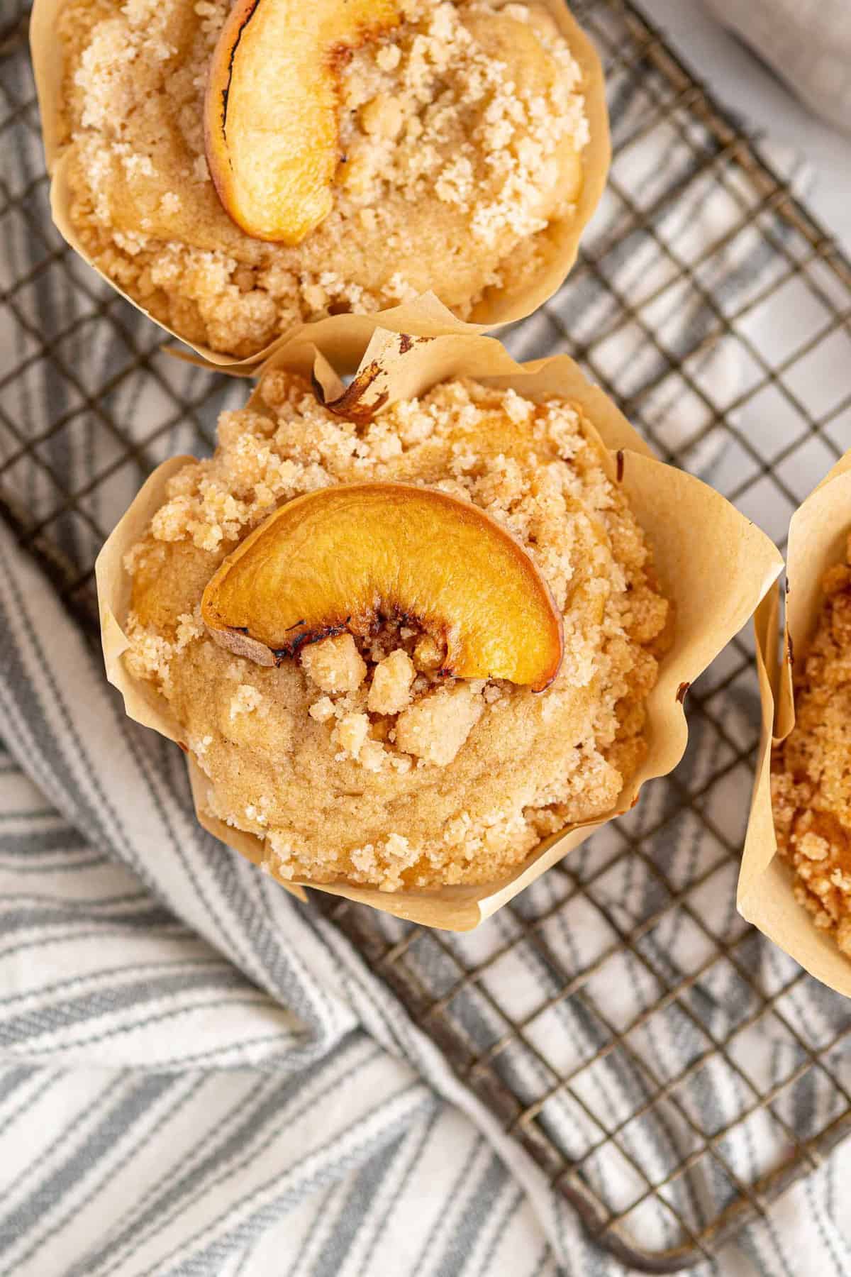 Vue aérienne d'un muffin surmonté de streusel et de tranche de pêche fraîche.