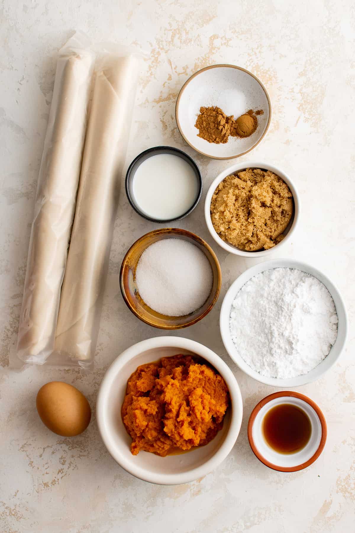 Vue d'ensemble des ingrédients nécessaires pour la recette, y compris des fonds de tarte et de la purée de citrouille.