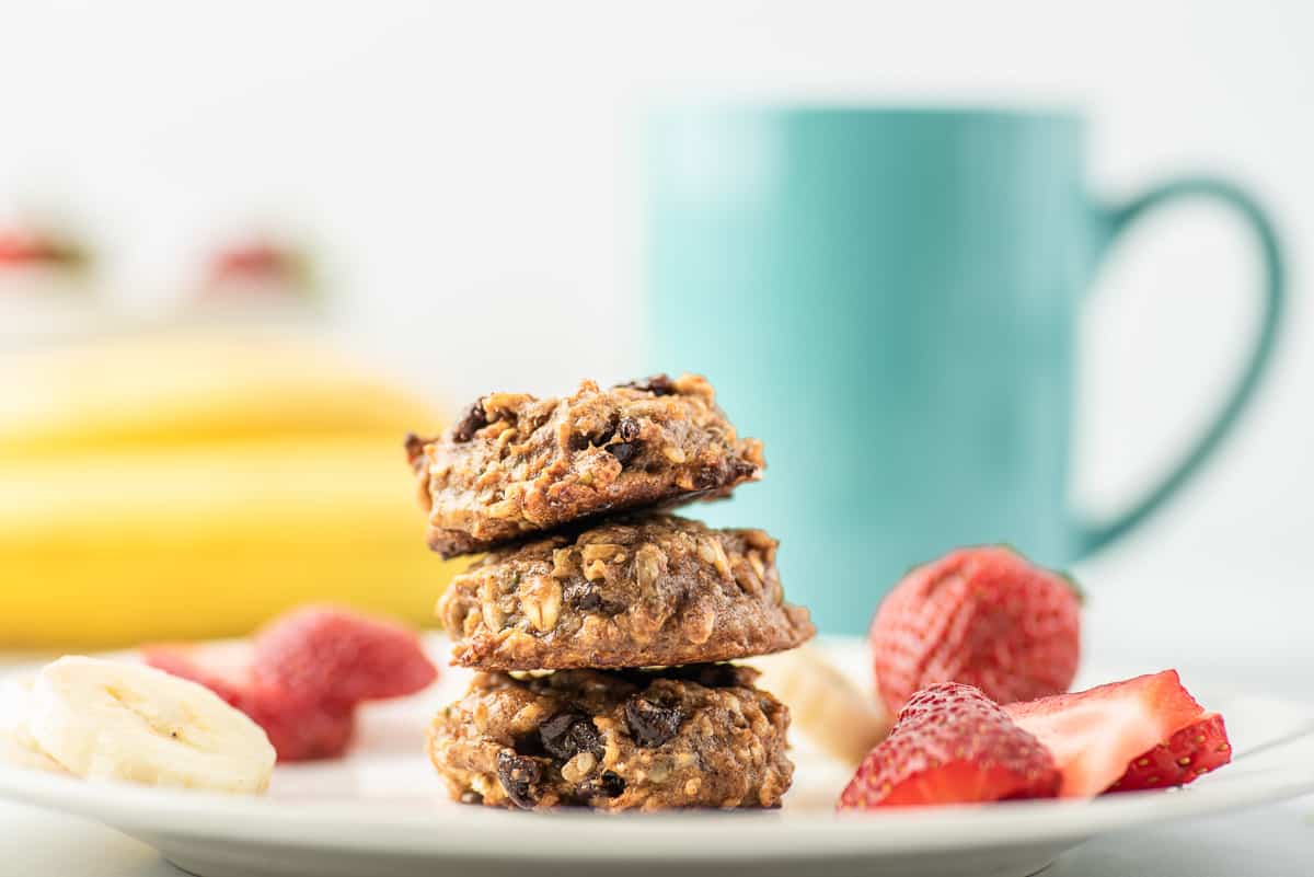 3 cookies de petit déjeuner sur une assiette avec des fruits.