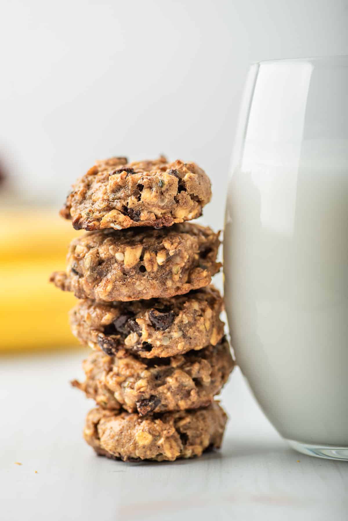 Cookies empilés à côté d'un grand verre de lait.