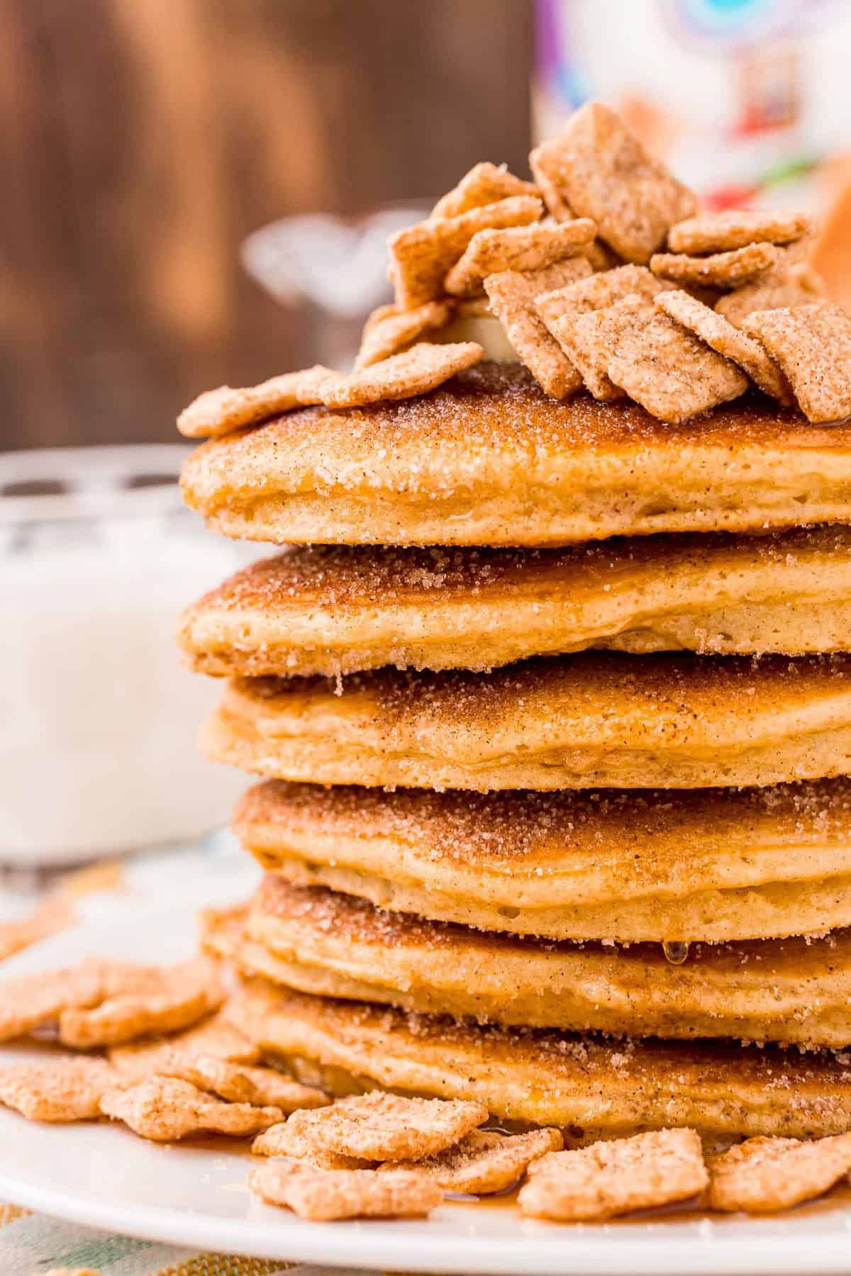 Gros plan d'une pile de pancakes à la cannelle garnis de céréales Cinnamon Toast Crunch.