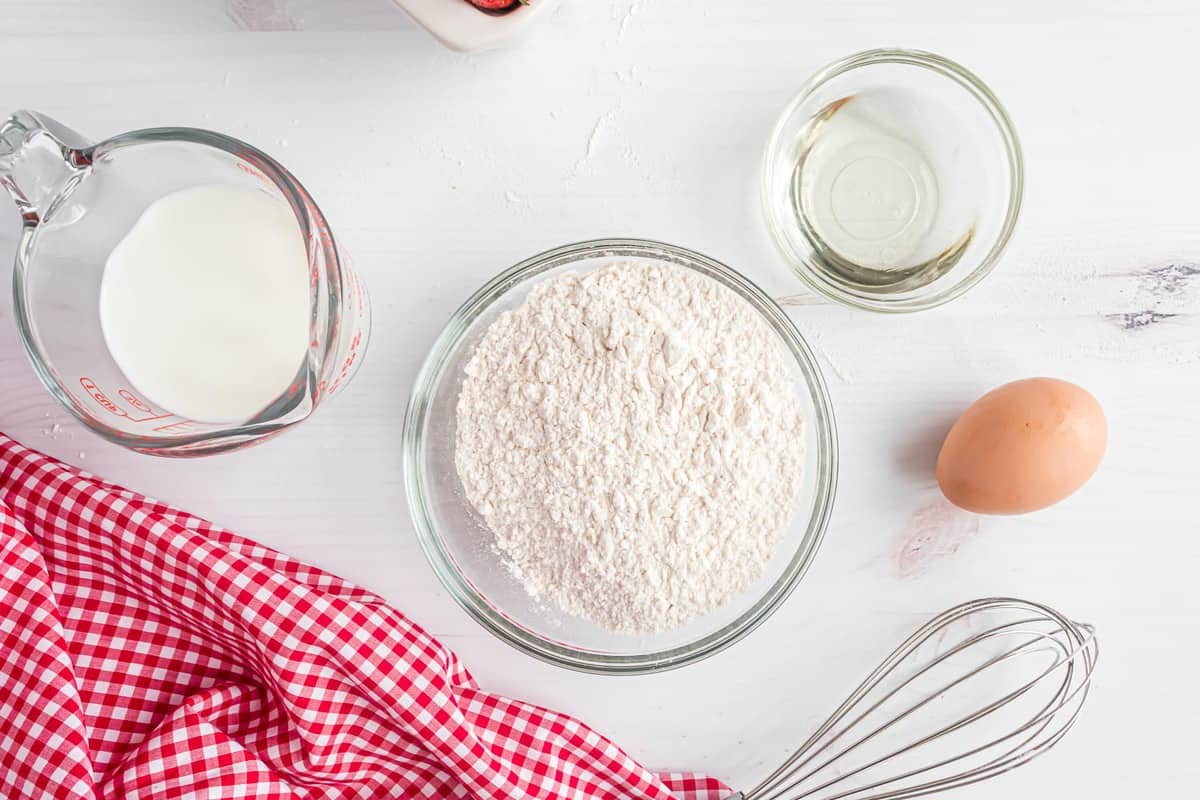 Ingrédients nécessaires pour réaliser des pancakes avec le mélange fait maison.