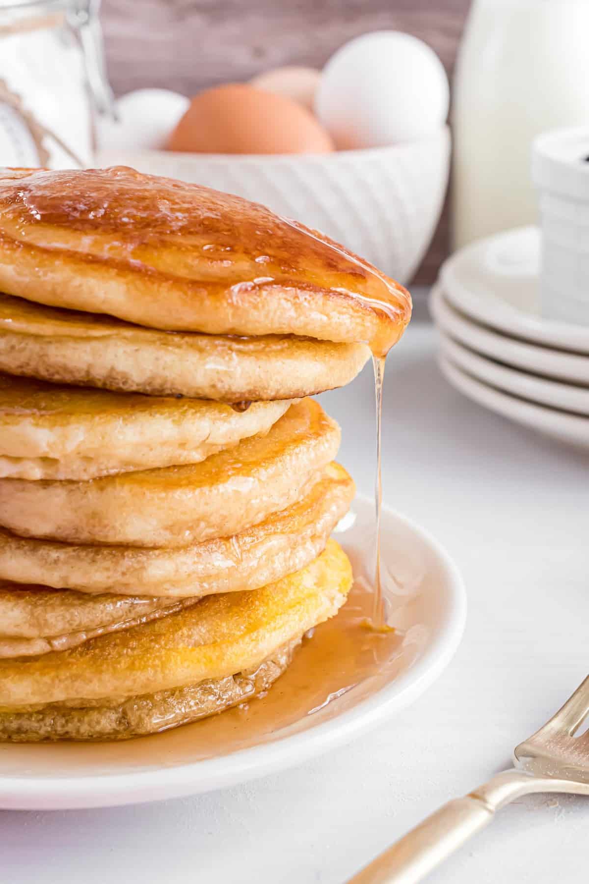 Sirop s'écoulant d'une pile de pancakes.