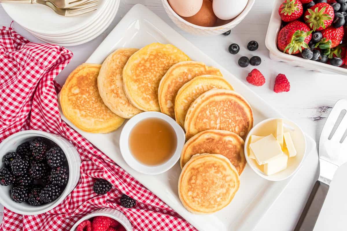 Pancakes disposés sur un plat rectangulaire blanc.