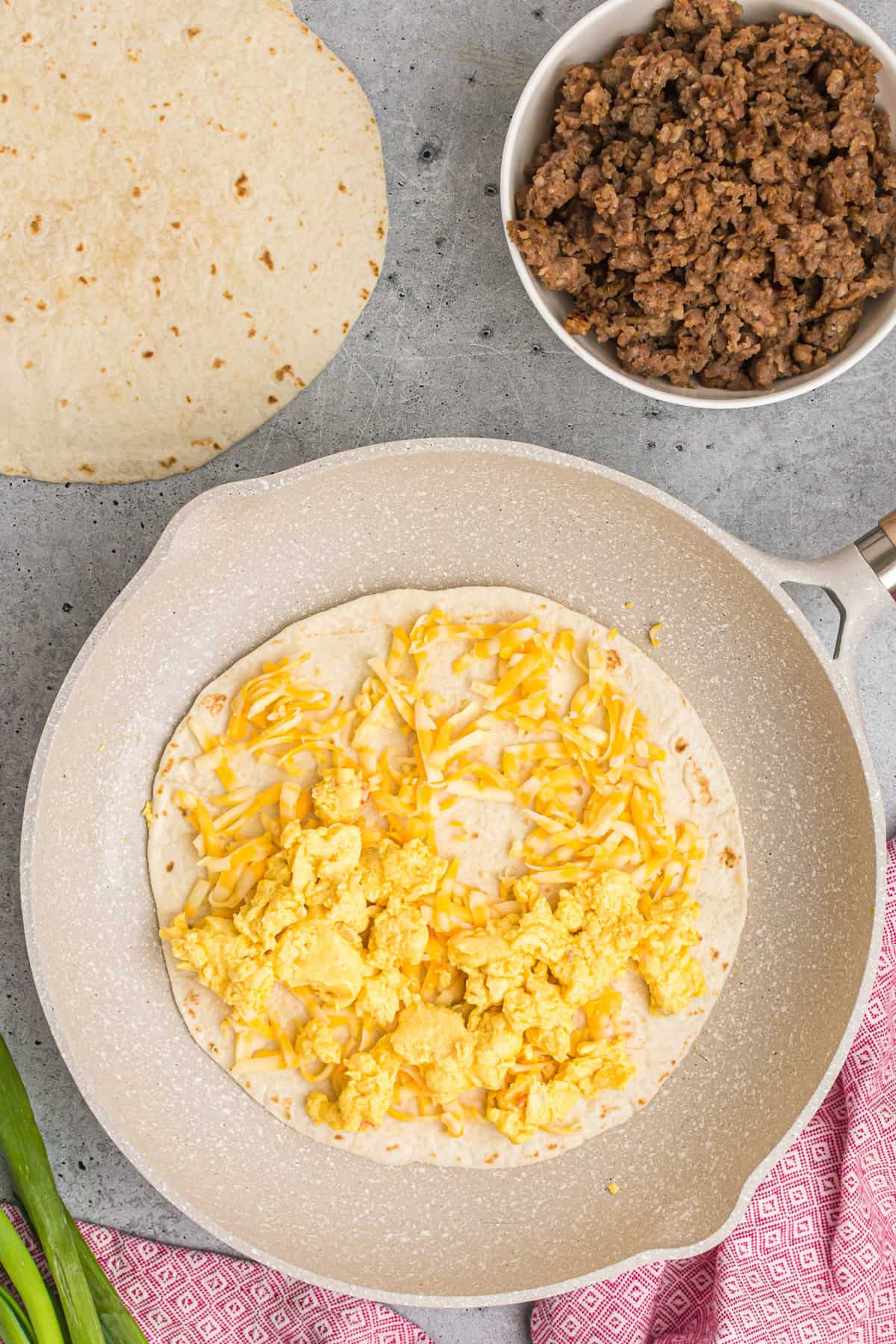 Œufs et fromage ajoutés à la poêle.